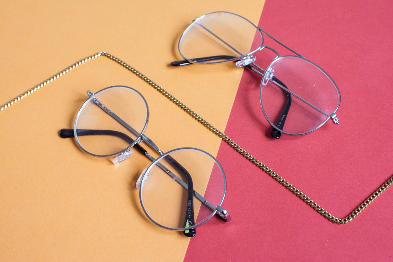 Mastering the First Impression: Your intriguing post title goes here Top-down view of stylish eyeglasses on a red and yellow background.